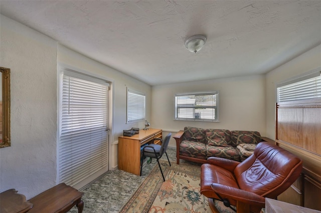 office area with a textured ceiling and a textured wall