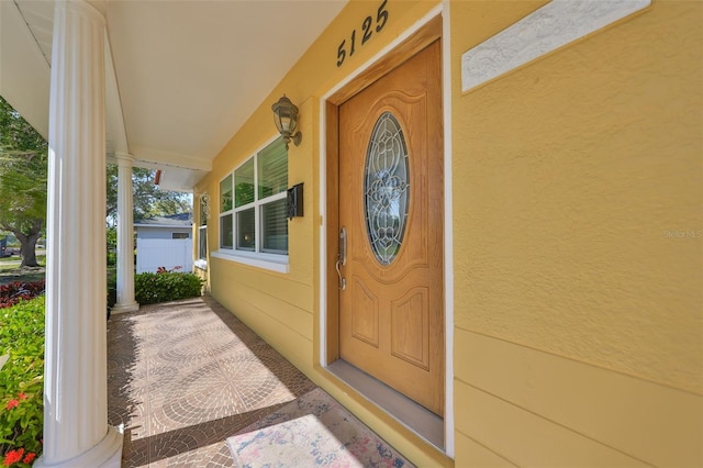 property entrance with a porch and stucco siding