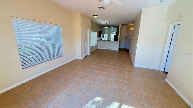 spare room with light tile patterned floors, baseboards, and visible vents