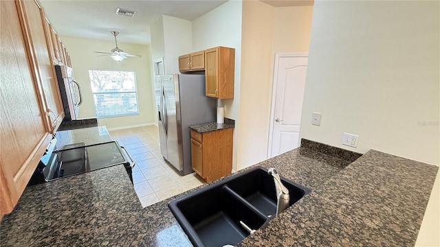 kitchen featuring visible vents, brown cabinets, a sink, electric range oven, and stainless steel fridge with ice dispenser