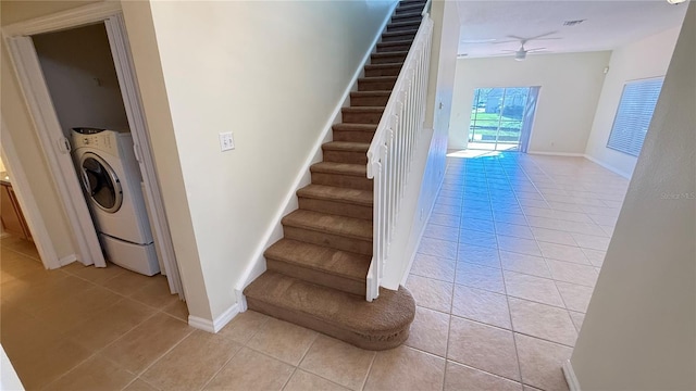 stairway with visible vents, baseboards, washer / clothes dryer, tile patterned floors, and a ceiling fan