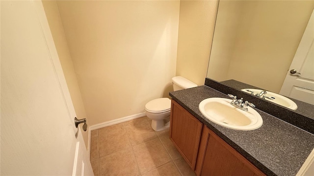 half bath featuring baseboards, toilet, tile patterned flooring, and vanity