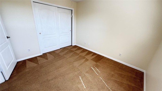 unfurnished bedroom featuring carpet flooring, a closet, and baseboards