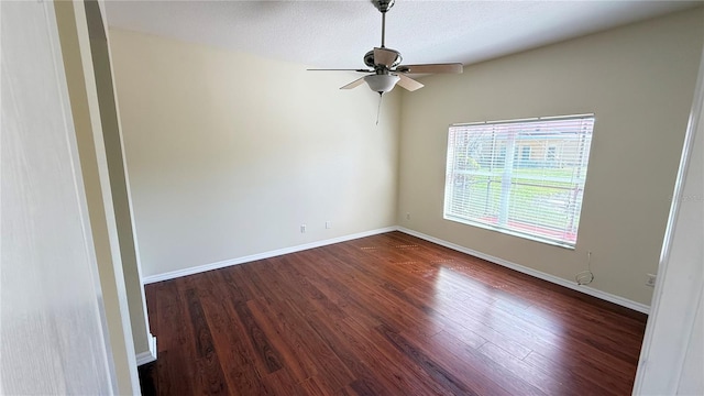 unfurnished room featuring baseboards, a textured ceiling, dark wood-style floors, and a ceiling fan