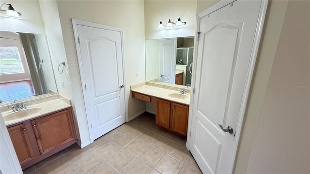 full bath featuring a sink, tile patterned flooring, two vanities, and a shower stall