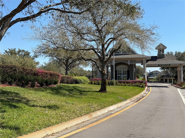view of street with a gated entry and curbs