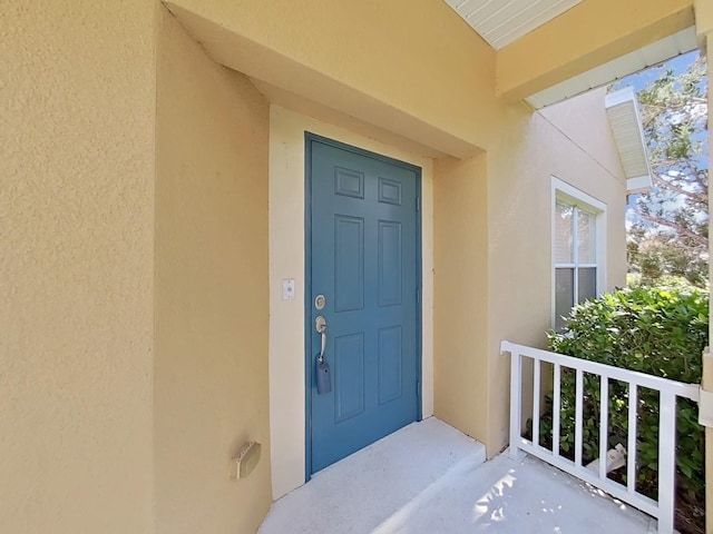 view of exterior entry featuring stucco siding