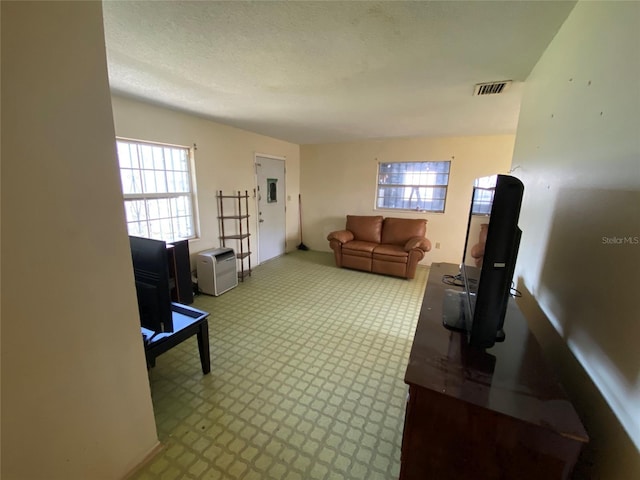 carpeted living room featuring a textured ceiling and visible vents