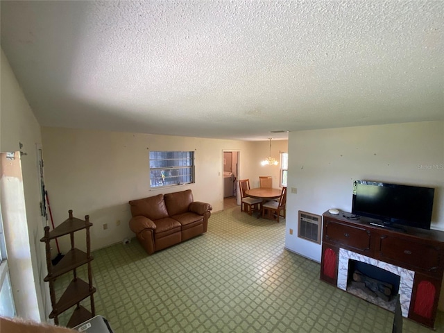 living room with a textured ceiling, a fireplace, and heating unit