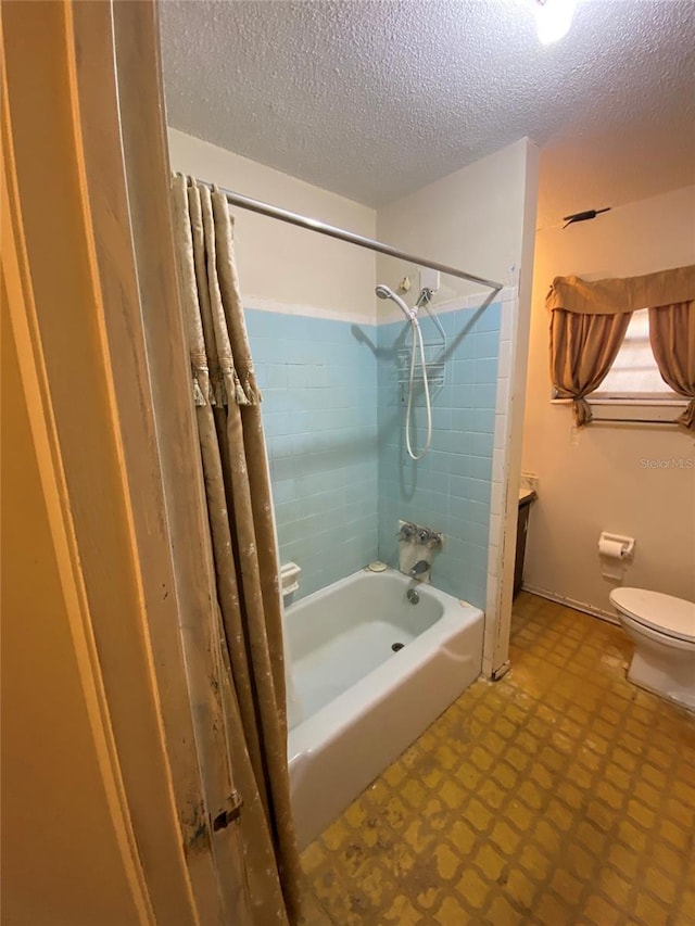 bathroom featuring toilet, shower / bathtub combination, a textured ceiling, and tile patterned floors