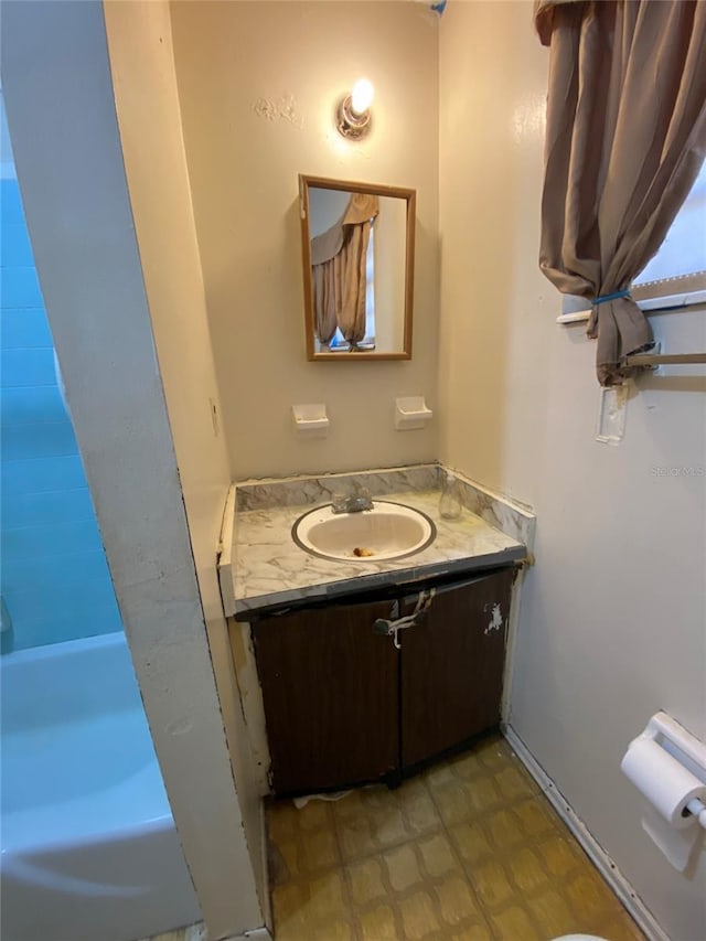 full bath featuring tile patterned floors, vanity, and a bathing tub