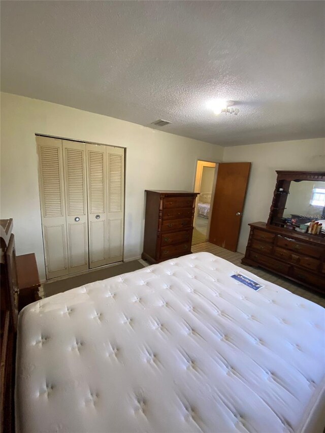 unfurnished bedroom with a textured ceiling, a closet, and visible vents