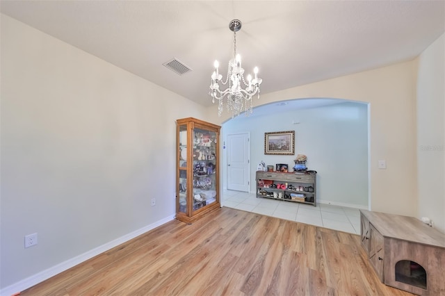 dining area featuring a chandelier, visible vents, light wood-style flooring, and baseboards