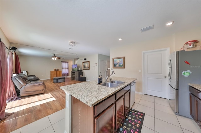 kitchen with light tile patterned floors, visible vents, stainless steel appliances, and a sink