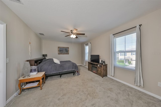 carpeted bedroom featuring ceiling fan, visible vents, and baseboards