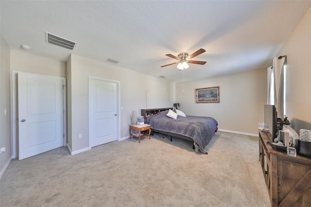 bedroom with light carpet, visible vents, and baseboards