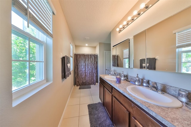 full bath with plenty of natural light, tile patterned flooring, and a sink