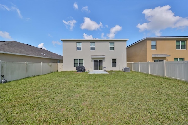 back of house with central AC unit, a lawn, a fenced backyard, and stucco siding