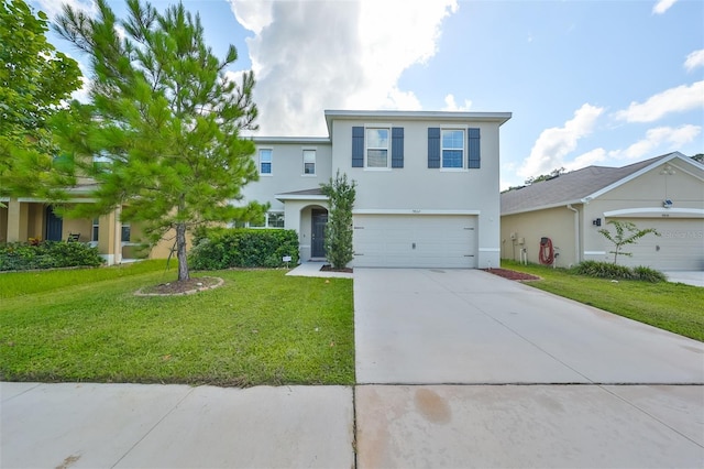 traditional home with a front yard, concrete driveway, an attached garage, and stucco siding