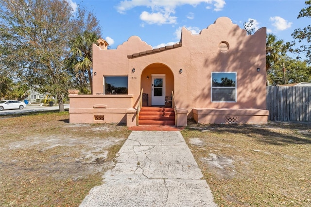 view of front facade featuring fence and stucco siding