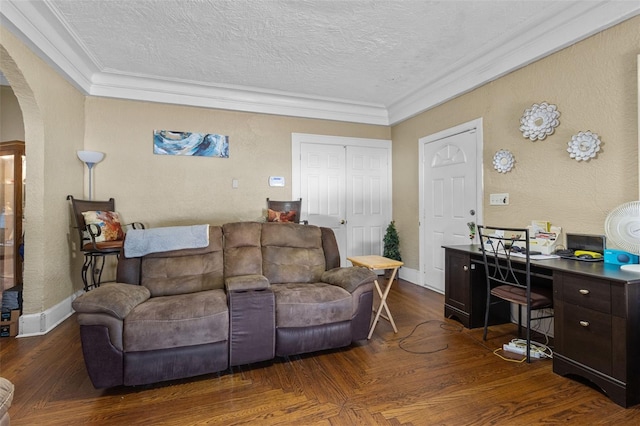 living area with arched walkways, a textured ceiling, wood finished floors, baseboards, and crown molding