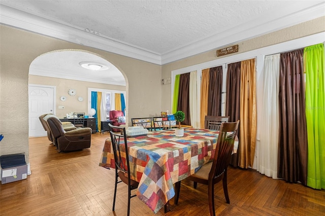 dining room featuring arched walkways, a textured ceiling, and crown molding