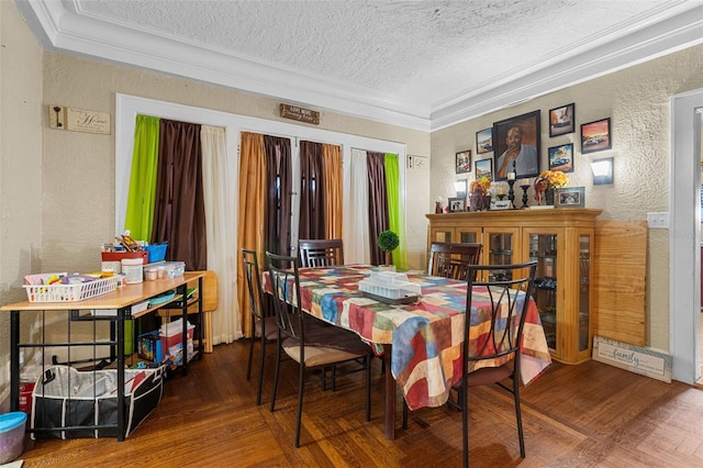 dining space featuring a textured ceiling, a textured wall, ornamental molding, and wood finished floors