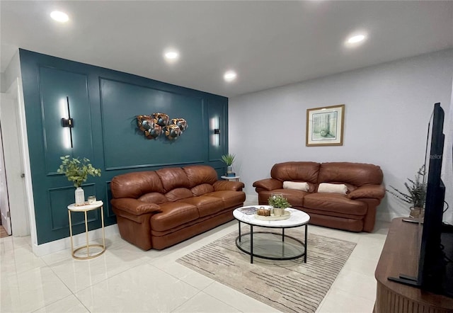 living area featuring light tile patterned floors, a decorative wall, and recessed lighting