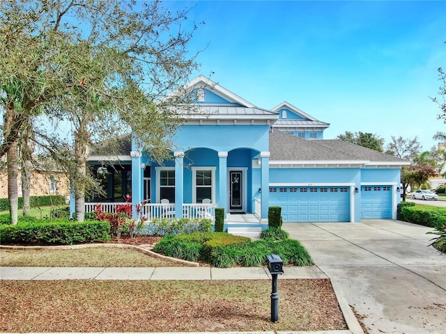 view of front of home with an attached garage, covered porch, a shingled roof, driveway, and stucco siding