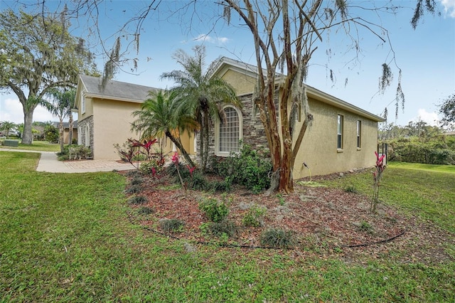 view of side of home featuring a lawn, a patio area, and stucco siding