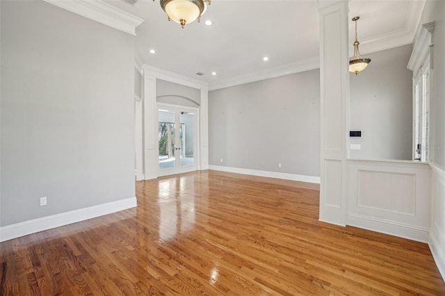 spare room with baseboards, light wood-style floors, and crown molding