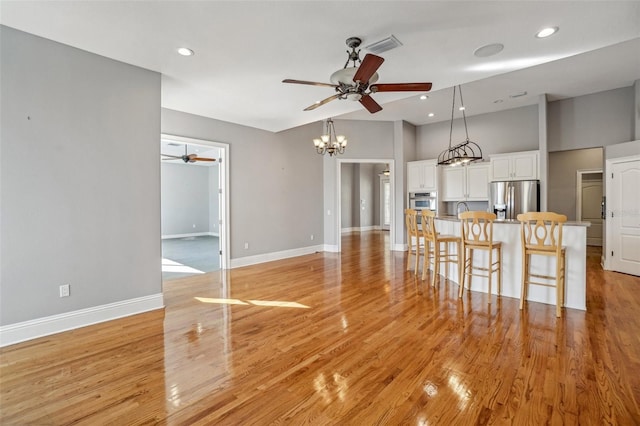 interior space with stainless steel appliances, white cabinetry, and light wood finished floors