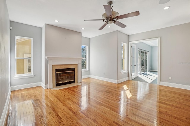 unfurnished living room with recessed lighting, a fireplace, wood finished floors, a ceiling fan, and baseboards