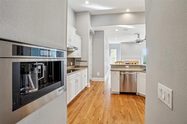 kitchen with stainless steel appliances, light wood-style floors, white cabinetry, and under cabinet range hood