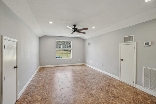 tiled empty room with lofted ceiling, baseboards, and visible vents