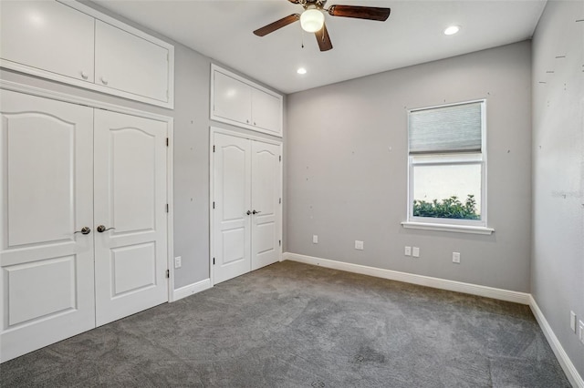 unfurnished bedroom with carpet, baseboards, recessed lighting, and two closets