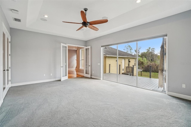 unfurnished bedroom featuring visible vents, baseboards, a raised ceiling, access to outside, and carpet flooring