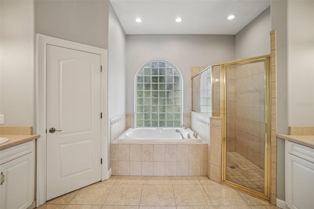 full bathroom with a stall shower, a garden tub, vanity, and tile patterned floors