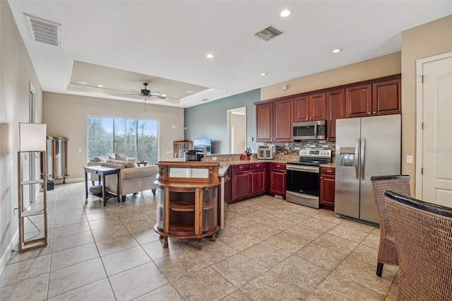 kitchen with stainless steel appliances, backsplash, a raised ceiling, and visible vents