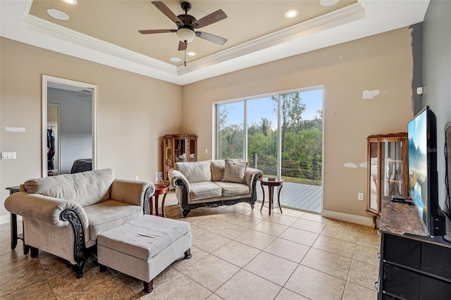 living area with baseboards, recessed lighting, a raised ceiling, and crown molding