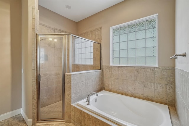 bathroom with a stall shower, a garden tub, and tile patterned floors