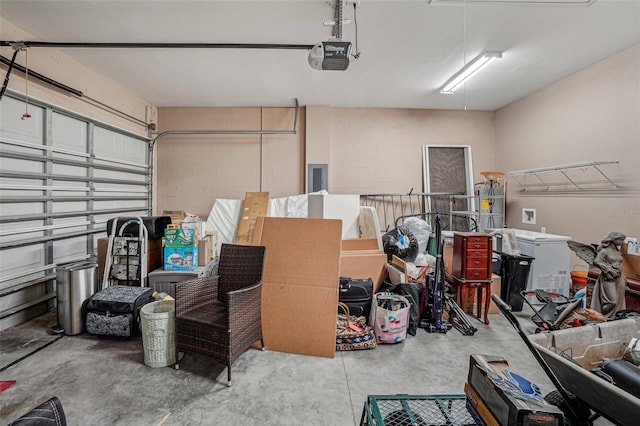 garage featuring concrete block wall, electric panel, and a garage door opener