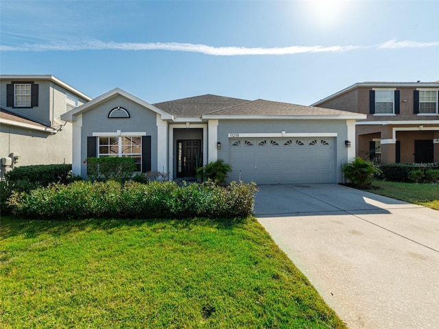 view of front of home featuring an attached garage, a shingled roof, driveway, stucco siding, and a front lawn