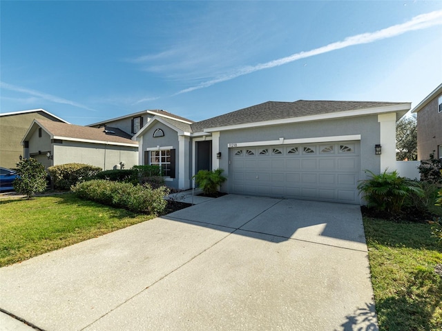 ranch-style home with a front lawn, driveway, an attached garage, and stucco siding