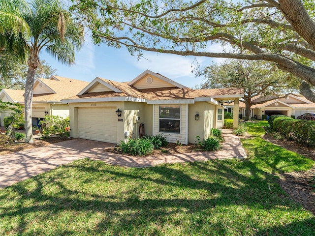 view of front facade with an attached garage, a front lawn, concrete driveway, and stucco siding