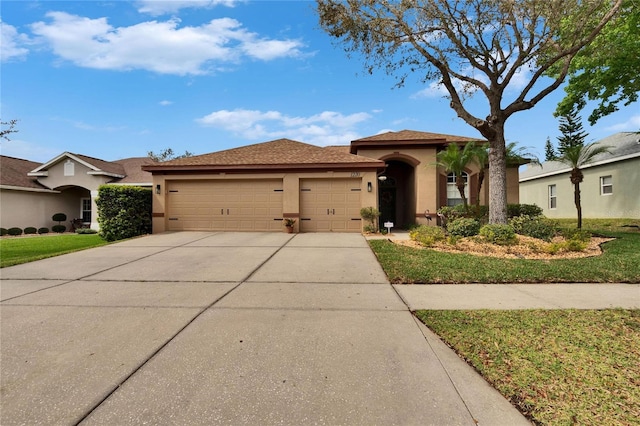 view of front facade featuring a front yard, concrete driveway, an attached garage, and stucco siding