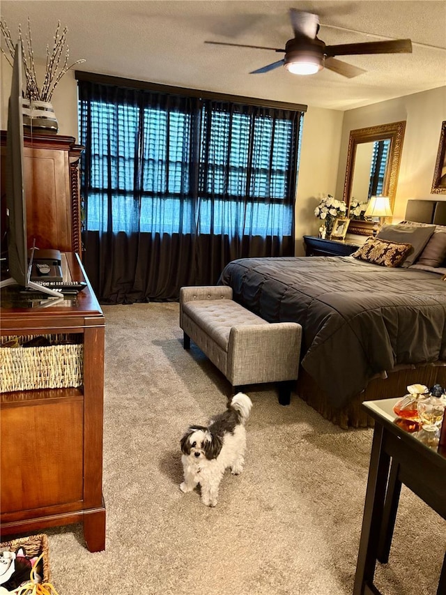 carpeted bedroom featuring ceiling fan and a textured ceiling