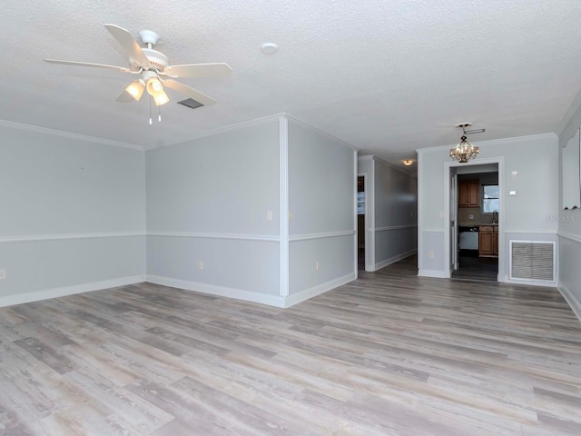 spare room with light wood finished floors, visible vents, and a textured ceiling