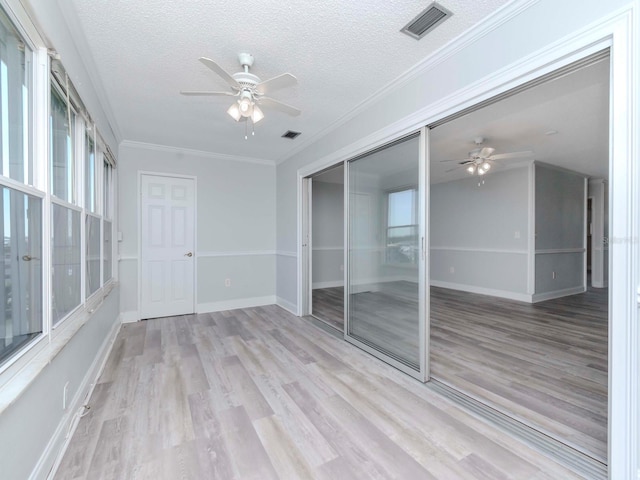 unfurnished sunroom with ceiling fan and visible vents