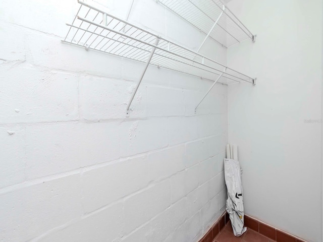 laundry area with concrete block wall